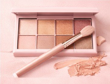 Powder eyeshadow palette with neutral and shimmer shades on a makeup table